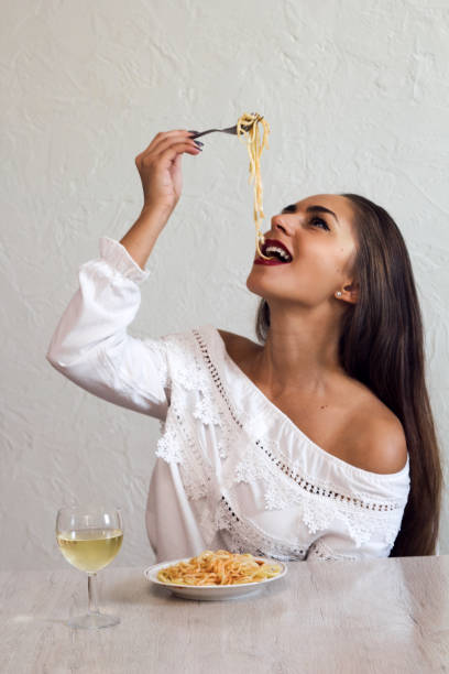 istock beautiful young woman eating pasta 1042034252