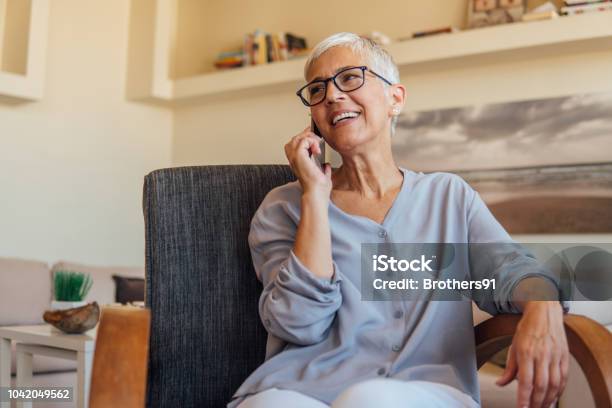 Photo libre de droit de Femme Dâge Mûr Parler Sur Téléphone Mobile banque d'images et plus d'images libres de droit de Utiliser un téléphone - Utiliser un téléphone, Femmes, Vie domestique