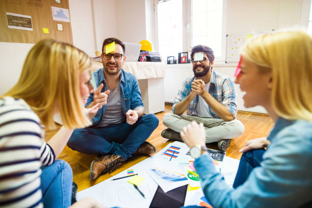 istock Team building. Group pf colleagues sitting in a circle and playing games and having fun. 1042054228
