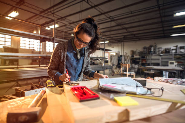 Picture of beautiful focused middle aged woman architect in her workshop working on new projects. Picture of beautiful focused middle aged woman architect in her workshop working on new projects. netherlands currency stock pictures, royalty-free photos & images