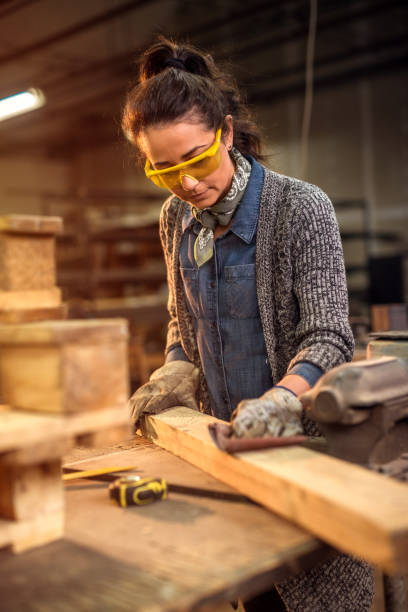 istock Middle aged professional female carpenter working with sandpaper in her workshop. 1042057664