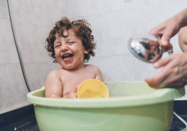 ragazzo che gioca nella vasca da bagno - bathtub child bathroom baby foto e immagini stock