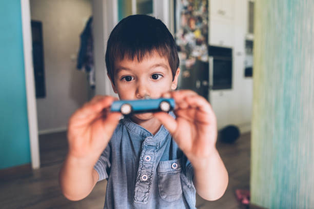 Boy playing with toy car Boy playing with toy car and showing at camera kid toy car stock pictures, royalty-free photos & images