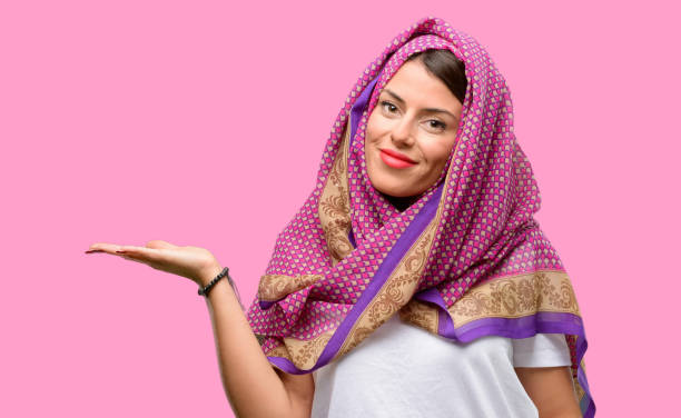 istock Young arab woman wearing hijab holding something in empty hand 1042065644