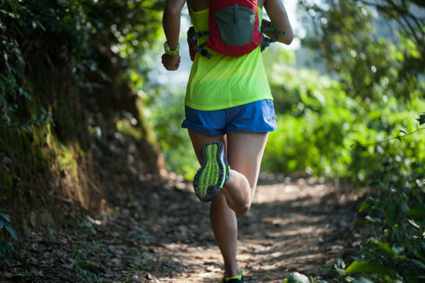 istock Young woman trail runner running on tropical forest trail 1042065942