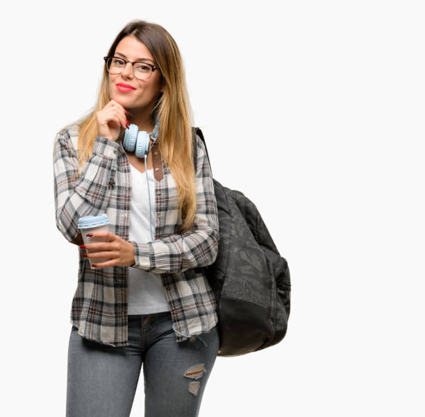 istock Young student woman with headphones and backpack thinking and looking up expressing doubt and wonder 1042066098