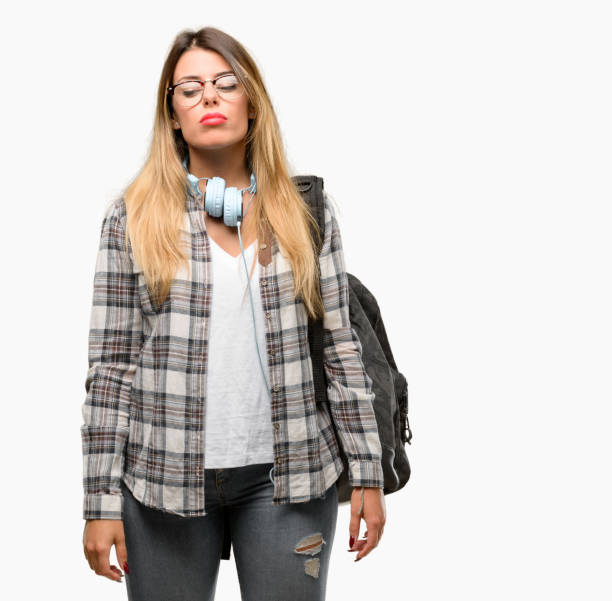 istock Young student woman with headphones and backpack with sleepy expression, being overworked and tired 1042066308
