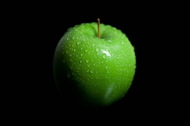 istock Wet droplets on green granny smith apple with black background 1042066646