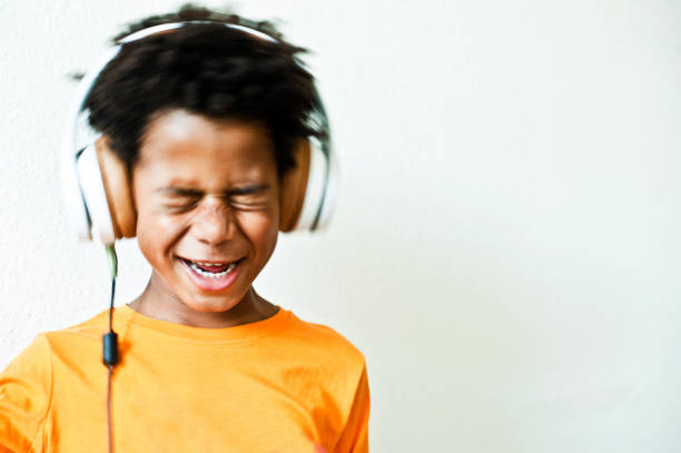 istock Head Shaking Little Boy With Eyes Closed Enjoying His Music 1042066802
