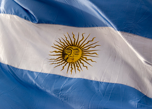 A large flag of of Argentina captured at the legendary Plaza de Mayo. This is a real flag, under real circumstances in open space and with daylight.