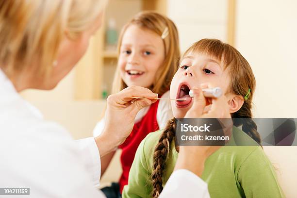 Pediatrician Doctor Examining Throat Of Girl Stock Photo - Download Image Now - Adult, Child, Color Image