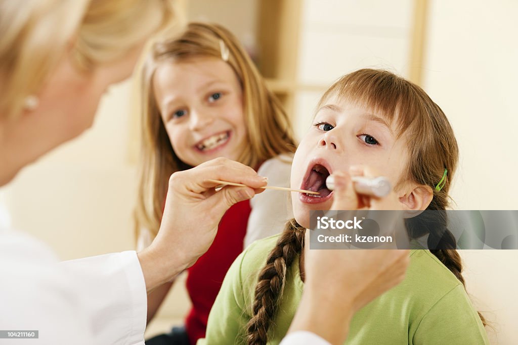 Pediatrician doctor examining throat of girl  Adult Stock Photo