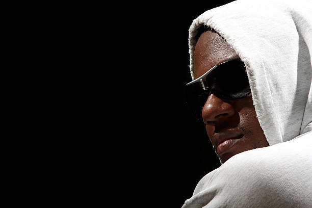 African-American man in black shirt wearing sunglasses against white background.