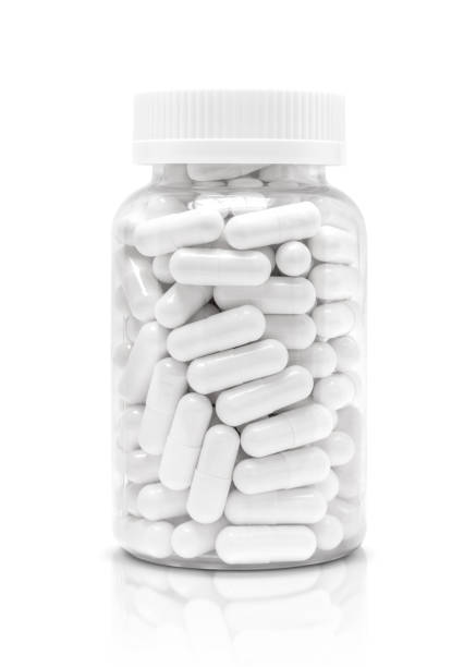 white medicine or supplement capsules in transparent plastic bottle - vitamin capsule fotos imagens e fotografias de stock