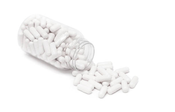 istock white medicine capsules spill out from transparent bottle 1042127138