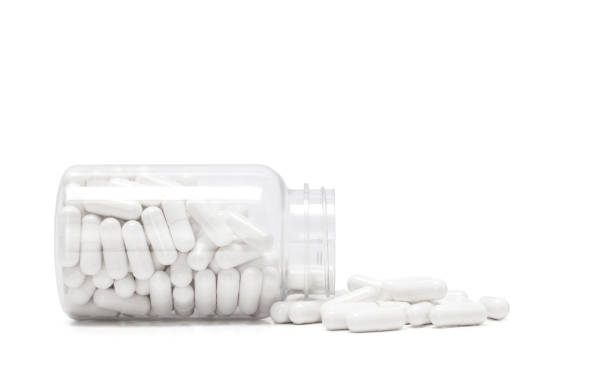 istock white medicine capsules spill out from transparent bottle 1042127140