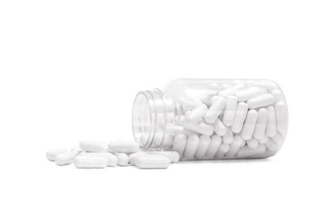 istock white medicine capsules spill out from transparent bottle 1042127146