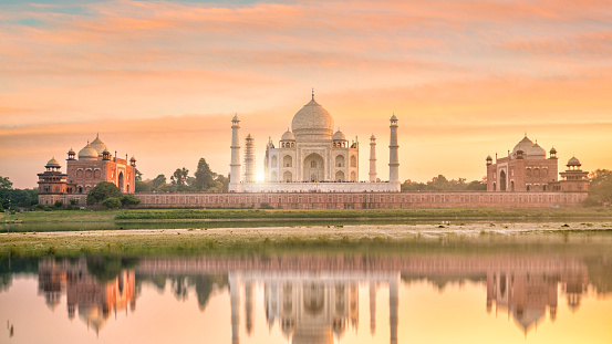 Panoramic view of Taj Mahal at sunset with reflection in Agra, India.