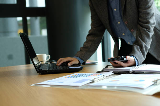 istock man organizing plan with smart phone. businessman working with computer at workplace 1042130664