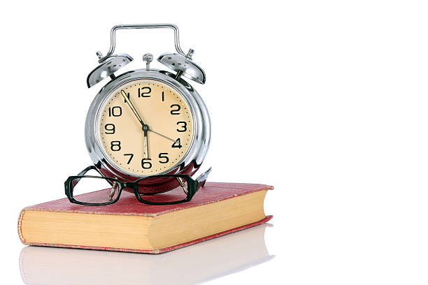 istock book with alarm clock and eyeglasses 104213299