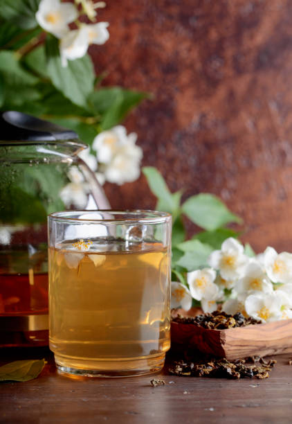 istock Green tea with jasmine in cup and teapot on old wooden table. 1042133988