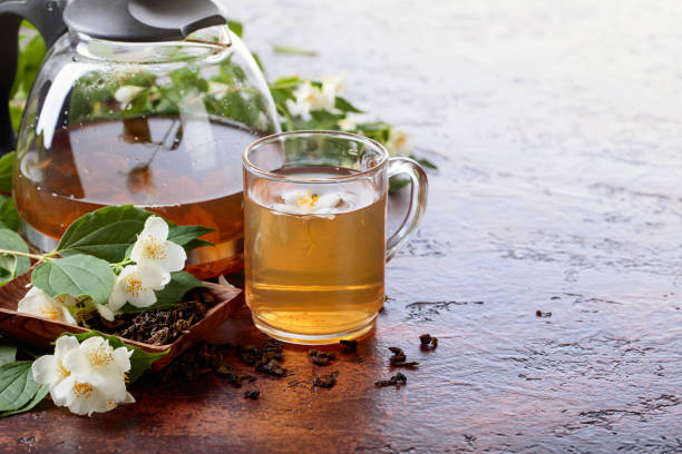 istock Green tea with jasmine in cup and teapot on old copper table. 1042134004