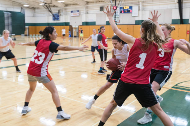 Women's college basketball practice A player dribbles through three defenders and tries to get a shot up during college basketball practice. She is holding the ball and about to jump. college basketball court stock pictures, royalty-free photos & images