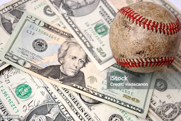 A Dirty Baseball Sitting On A Pile Of Money Stock Photo - Download Image Now - Abundance, Banking, Base - Sports Equipment