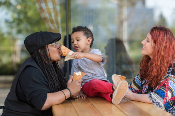 istock Two moms eat ice cream with their three-year old son 1042152776