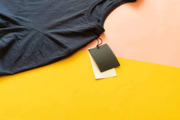 nowy casual t-shirt z ceną sprzedaży tag z kopią przestrzeni izolowane na różowym i żółtym tle f - label clothing shirt blank zdjęcia i obrazy z banku zdjęć