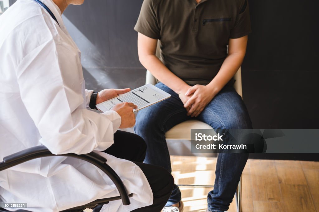 Male doctor and testicular cancer patient are discussing about testicular cancer test report. Testicular cancer and prostate cancer concept. Men Stock Photo