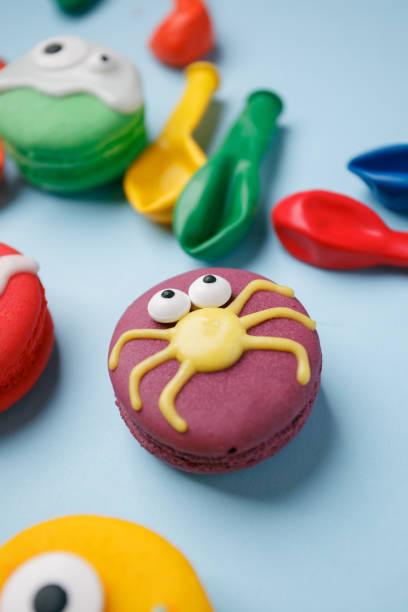 istock Delicious Halloween macaroons set with bright decorations made of confectionery mastic. Halloween sweets, homemade confectionery, holiday food, trick or treat concept 1042159496