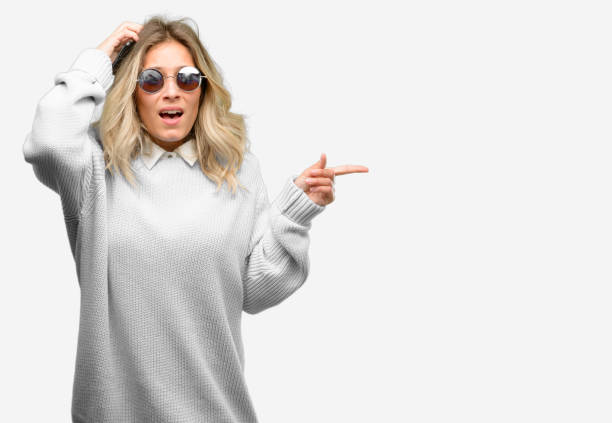 istock Young beautiful woman using smartphone pointing away side with finger 1042160556