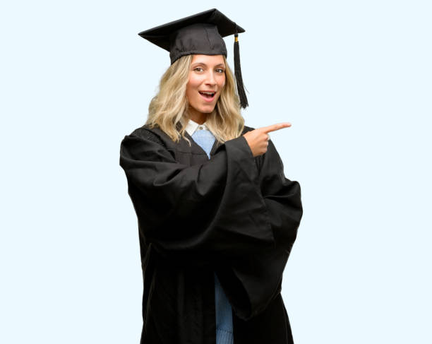 istock Young graduate woman pointing away side with finger 1042160906