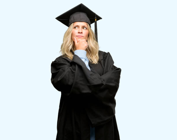 Young graduate woman thinking and looking up expressing doubt and wonder