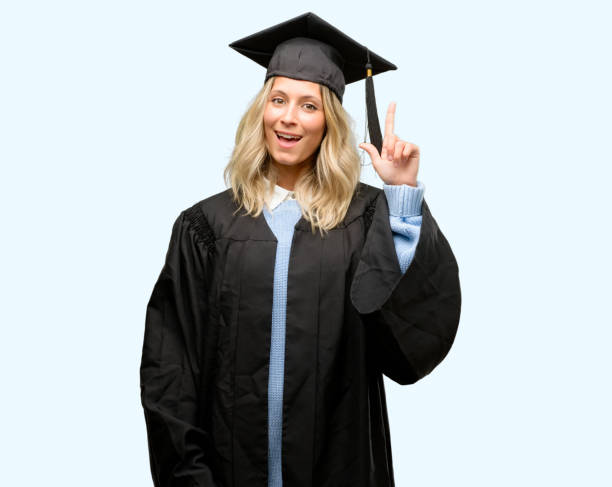 istock Young graduate woman pointing away side with finger 1042161096