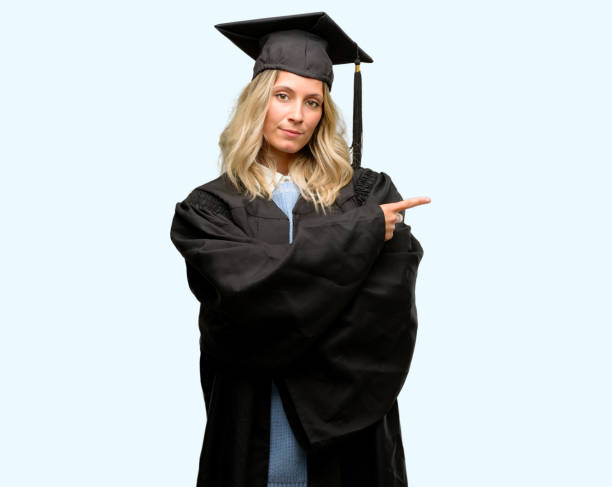 istock Young graduate woman pointing away side with finger 1042161116