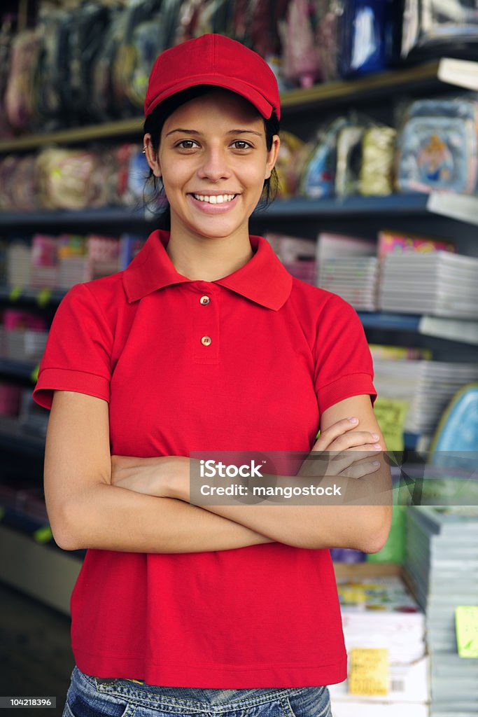 Młoda kobieta w pracy w sklepie artykuły biurowe - Zbiór zdjęć royalty-free (Koszulka polo)