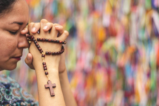 istock Woman praying with rosary in hands 1042204672