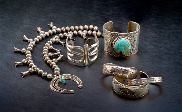 Sterling Silver Native American Jewelry. A Collection of Sterling Silver Native American Jewelry. Squash Blossom Necklace, Two Cuff Bracelets, One with a large Turquoise Stone, and Three smaller Bracelets. hopi culture photos stock pictures, royalty-free photos & images