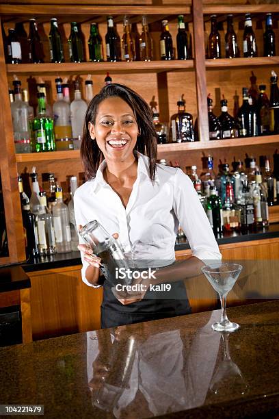 Felice Afroamericana Donna Di Miscelazione Di Cocktail Barman Dietro Il Bancone - Fotografie stock e altre immagini di Barman