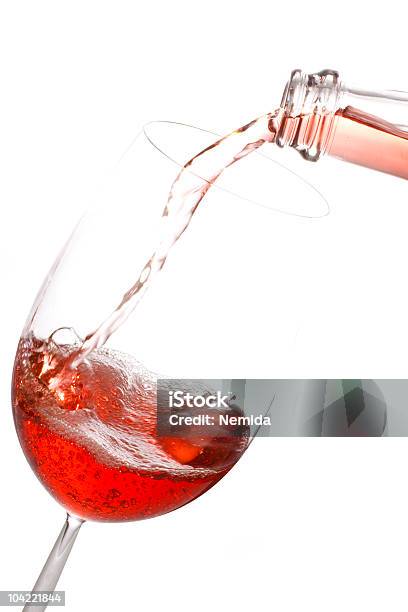 Photo libre de droit de Une Bouteille De Vin Rosé Verser Dans Un Verre Sur Fond Blanc banque d'images et plus d'images libres de droit de Vin rosé