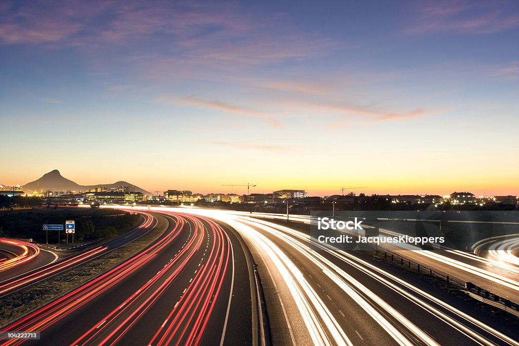 Trafficata strada urbana al crepuscolo - Foto stock royalty-free di Autostrada a corsie multiple