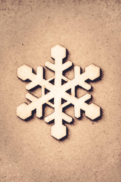 Wooden Decorative Snowflake on Craft Paper Background, as the Christmas Decor. Tinted photo