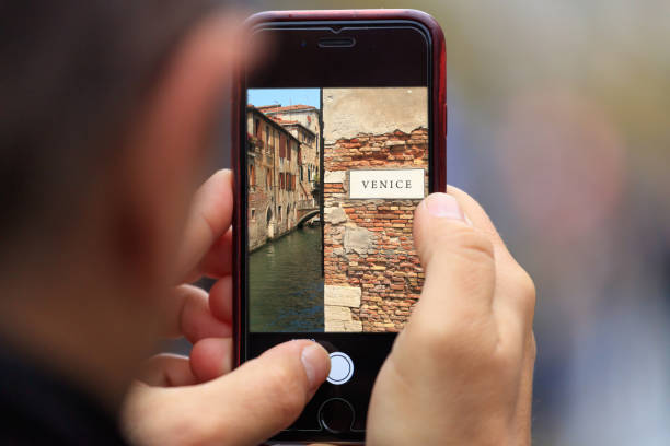 イタリア写真のヴェネツィアは、男の手でスマート フォン、タブレットに表示されます。背景をぼかした写真 - men gondolier people activity ストックフォトと画像