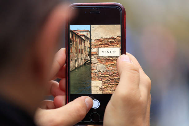 venice in italy picture appears on tablet, smartphone in man's hands. blurred background - men gondolier people activity imagens e fotografias de stock