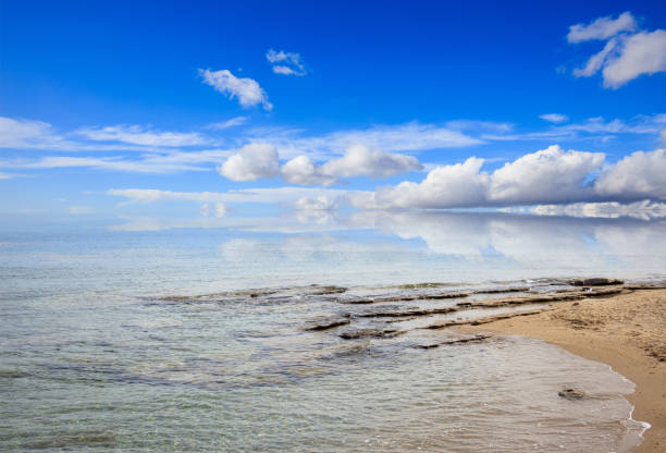istock Sandy beach with rocks. Blue sky and sea background. 1042241168