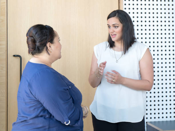 ritratto candido di donne d'affari che conversano nella sala riunioni dell'ufficio. le femmine sono di etnia maori. - heavy work foto e immagini stock