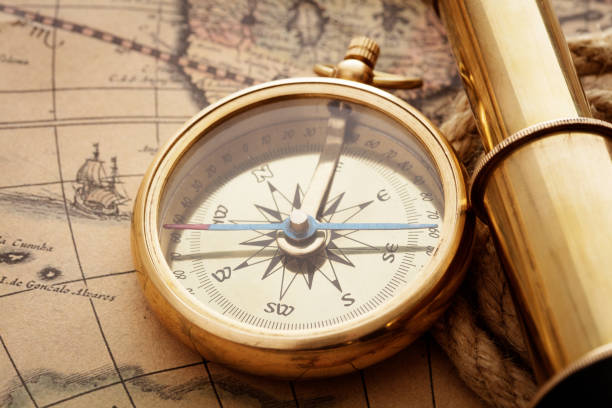 istock antique compass, magnifier, spyglass on map 1042273322