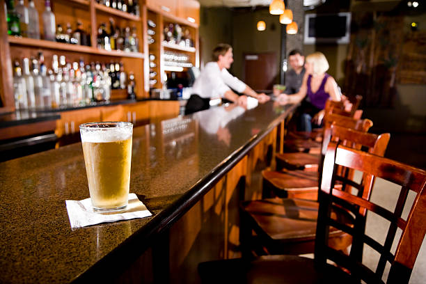 ビールを味わったり、バーテンダーのバーカウンターが、お客様の背景 - drinking couple bar counter bar ストックフォトと画像